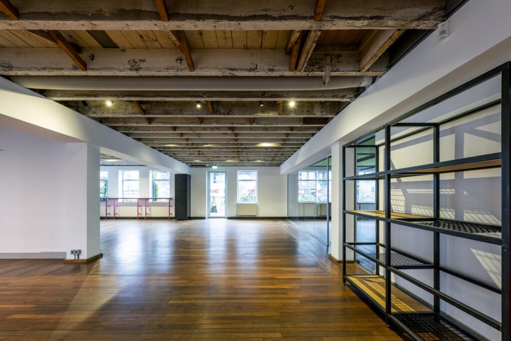 Open en licht kantoorpand aan de De Ruijterkade met houten vloer, industriële plafonds en grote ramen.